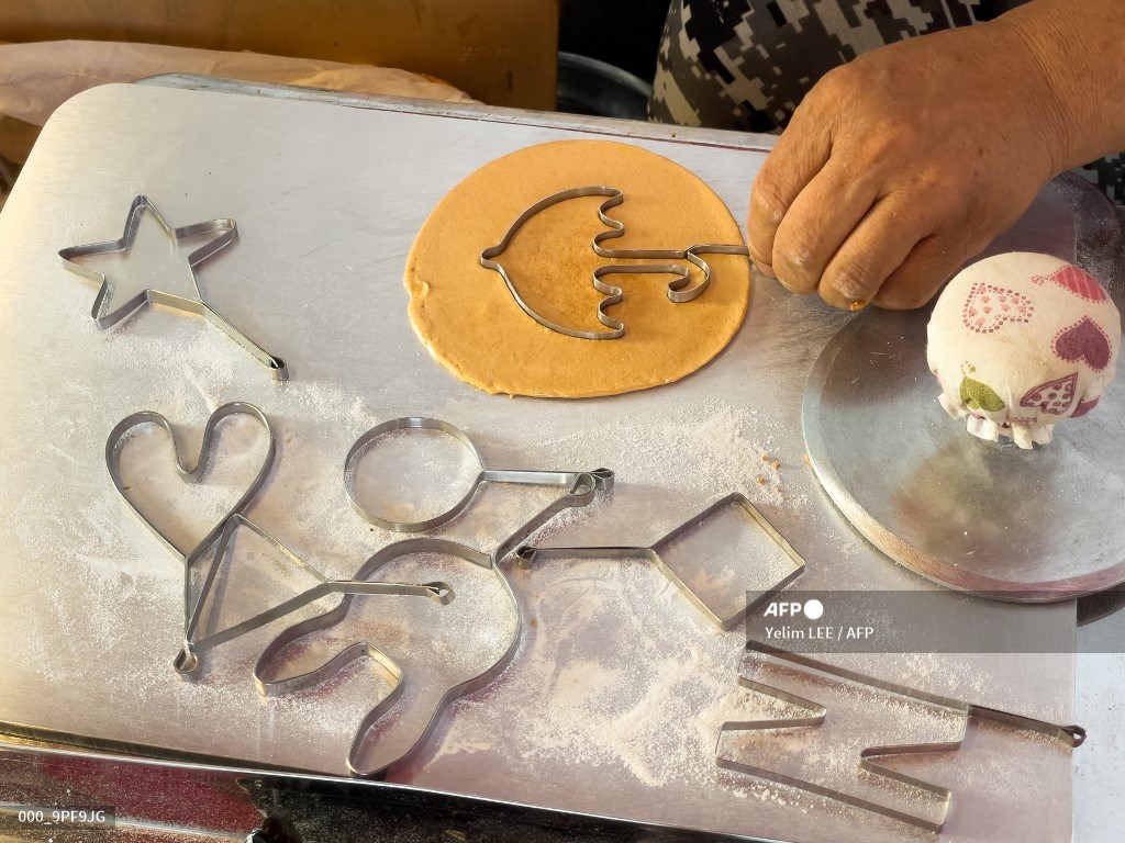 AFPphoto's tweet photo. Sweet taste of Squid Game success for South Korean candy couple. 
 📸 @yelimlee #AFP 
https://t.co/LeYhYunJgp https://t.co/H8HFEUbCO3