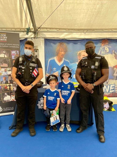 SuffolkPolice's tweet photo. Two of our officers with our Positive Action Recruitment Advisor were at #ITFC in the FanZone on Sat speaking to fans about #BlackHistoryMonth celebrating diversity in policing – many younger visitors took photos with the officers with police hats/jackets on. https://t.co/1e1vjoS03Y