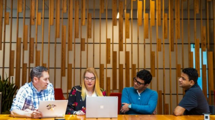 People working in a conference room working on laptops.