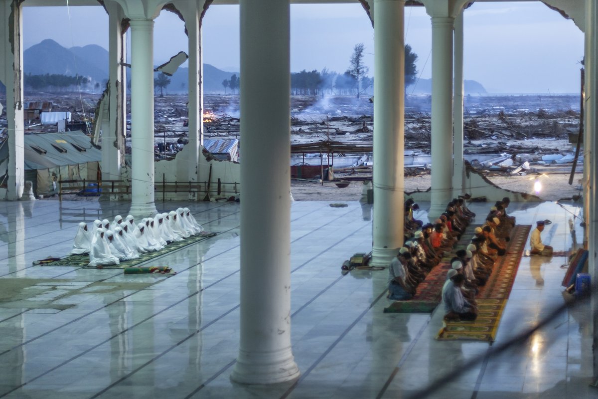 VIIPhoto's tweet photo. From the #VIIArchive. Photo by @JohnStanmeyer / @VIIPhoto. The surviving residents of Lampuuk village pray in a mosque, the only standing structure of a city completely decimated by the 2004 Indian Ocean tsunami which hit Aceh, Indonesia. February 9, 2005.⁠ #DRRDay https://t.co/GqeyBspadC