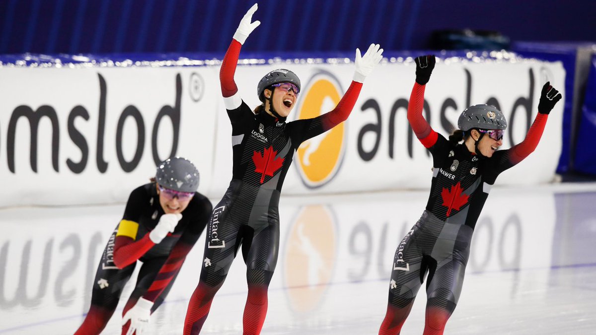 Valerie Maltais, center, Ivanie Blondin, right, raise their hands in the air while Isabelle Weidemann, left, bends down and has her hand by her face, after they set a new track record and won the women’s team pursuit race.