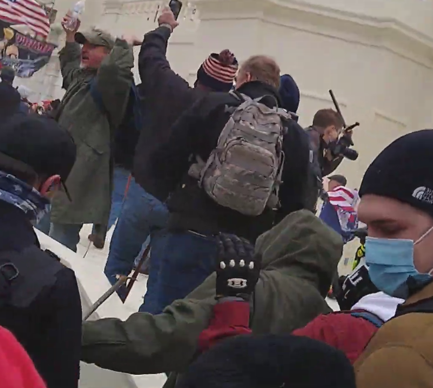 MalagaBridget's tweet photo. @phoenixonwheels @sally_sleuth Here's another odd object from same video (pic 1). It is only on screen for a second. I didn't see it used for anything, just not sure what it is. Also appears to be #seditionweapon of some sort held by guy in green coat (pics 2-4). Small rod with pick type blade, or eagle? https://t.co/Ixzrsc5QhD