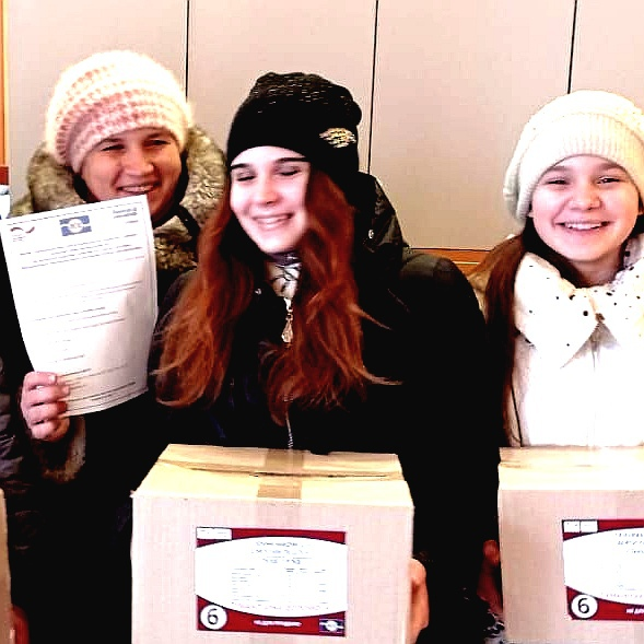 Eine Mutter mit ihren zwei jugendlichen Töchtern haben Hilfspakete abgeholt