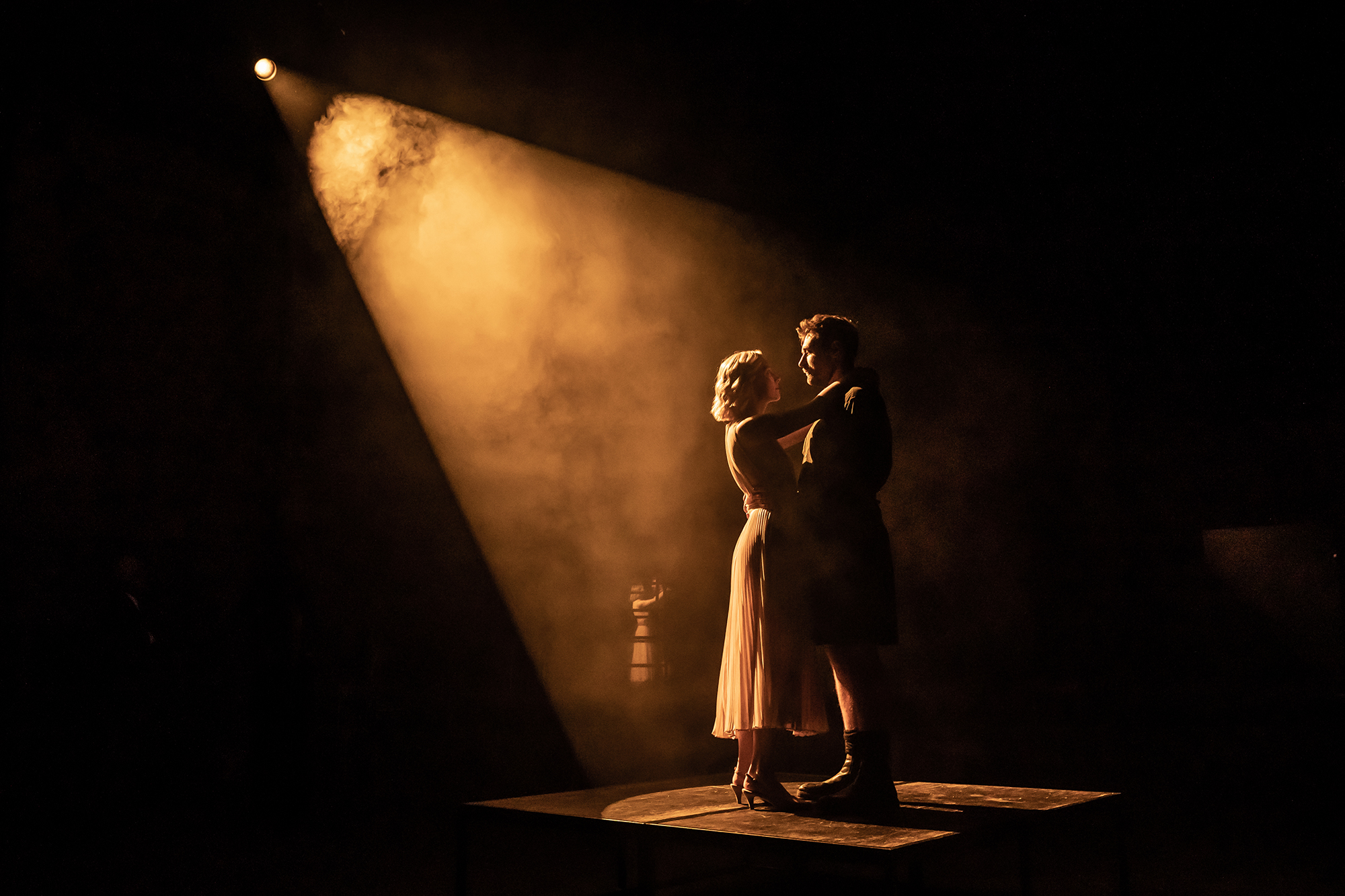 Silhouette of Saoirse Ronan and James McArdle on stage as Lady Macbeth and Macbeth. They are holding each other dancing.