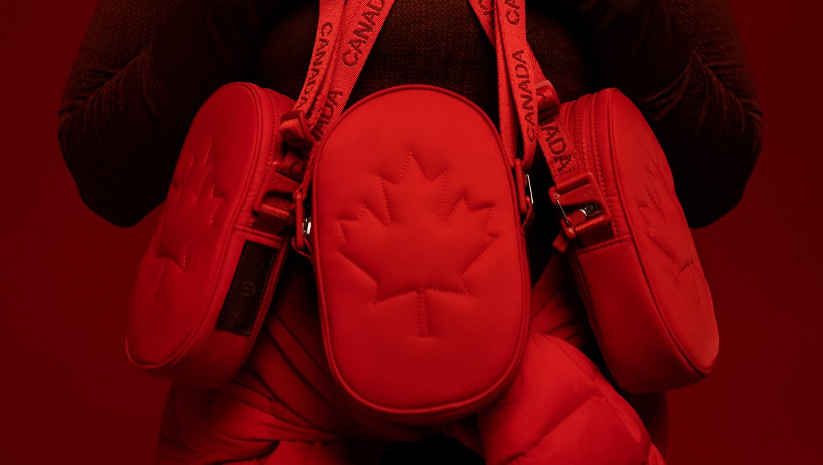 A close up of three red Future Legacy Bags. There is a big maple leaf outline on the front of the bag. The straps (also red) have CANADA repeated on the strap.