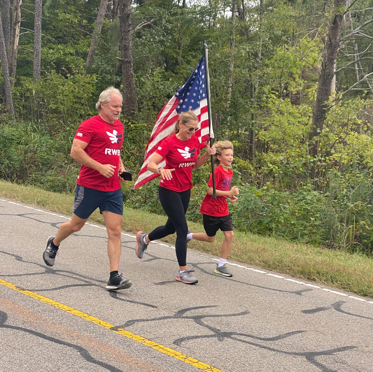 Photo of a Team R-W-B family running with the American Flag.