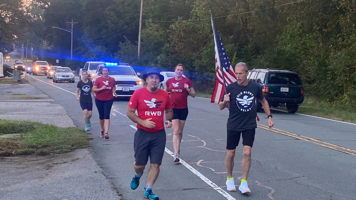Photo of Team R-W-B members running with the American Flag.