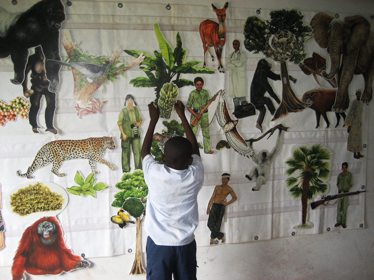 Child placing a cutout image on a board.