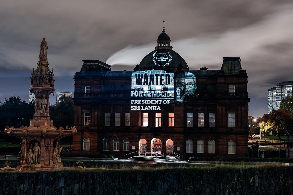 TamilGuardian's tweet photo. ‘Rajapaksa of Sri Lanka, Wanted for Genocide’ – Scottish Parliament lit up ahead of Gotabaya visit

Projections across Scotland, including on the Scottish Parliament Building in Edinburgh, called for international accountability for the Tamil genocide.

https://t.co/6ZAFuALezp https://t.co/L6ZqhLiboz