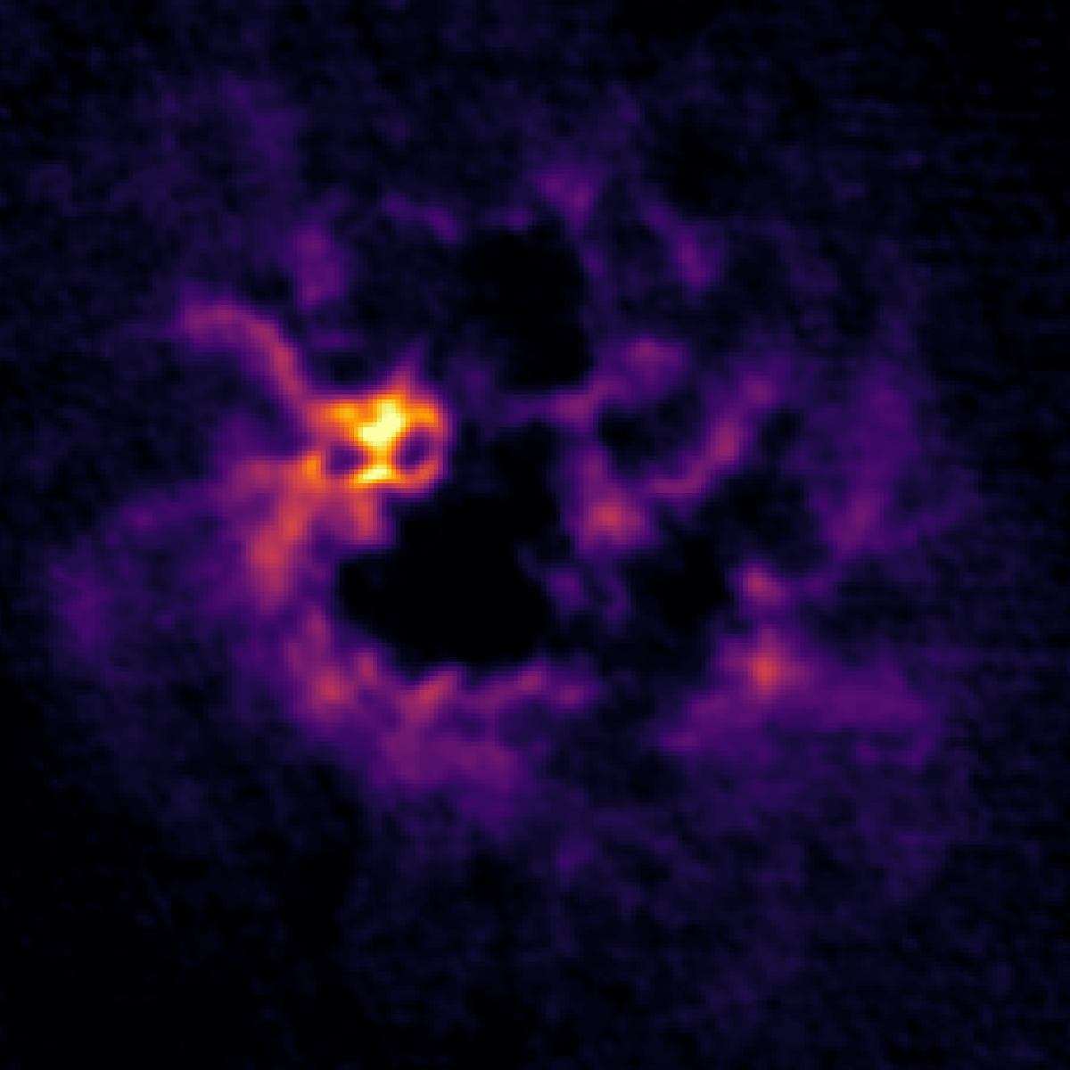 Galaxy IC1613 shown in L-band as purple, yellow and orange gas, giving the galaxy the appearance of a skull or angry jack o'lantern.