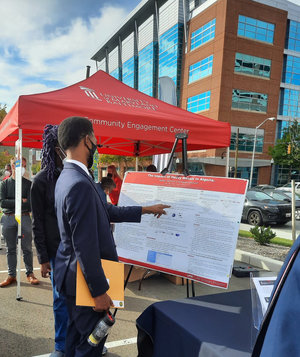 UMB_CURE's tweet photo. Cohort 3 CURE scholar, Najah Johnson, presenting her research poster on “The Heavy Metals in Algeria” to Mayor Brandon Scott!
#UMBCure #UMBaltimore #CECOpening #UMBFounders22 #NIHSepa https://t.co/Opuwame7Qs