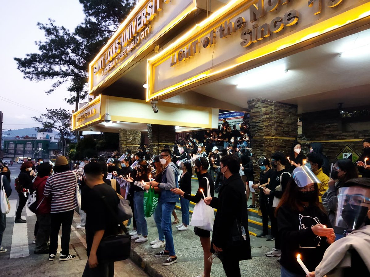 eleps_slu's tweet photo. NOW HAPPENING: Louisians stage a lightning protest and a candle lighting ceremony in front of Saint Louis University's main gate to assert the call for #AcademicBreakNowSLU after months of being deprived of any wellness break from distance learning. https://t.co/BkL25CJA3A