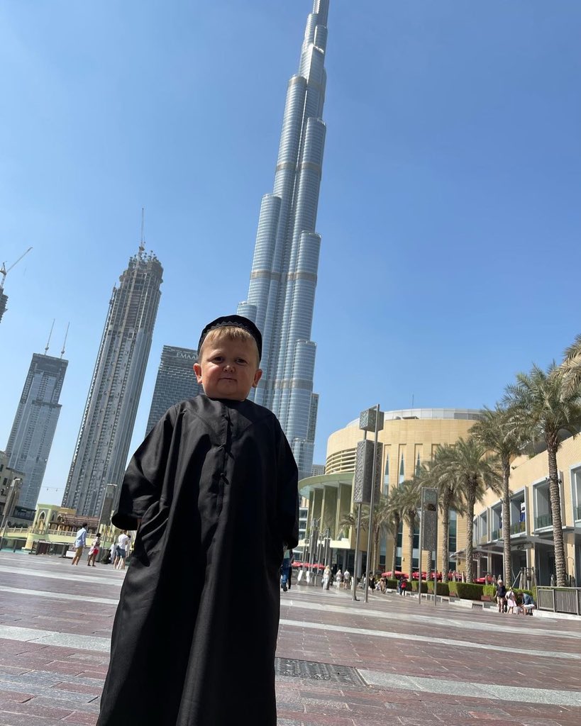 Tallest man on planet next to a building