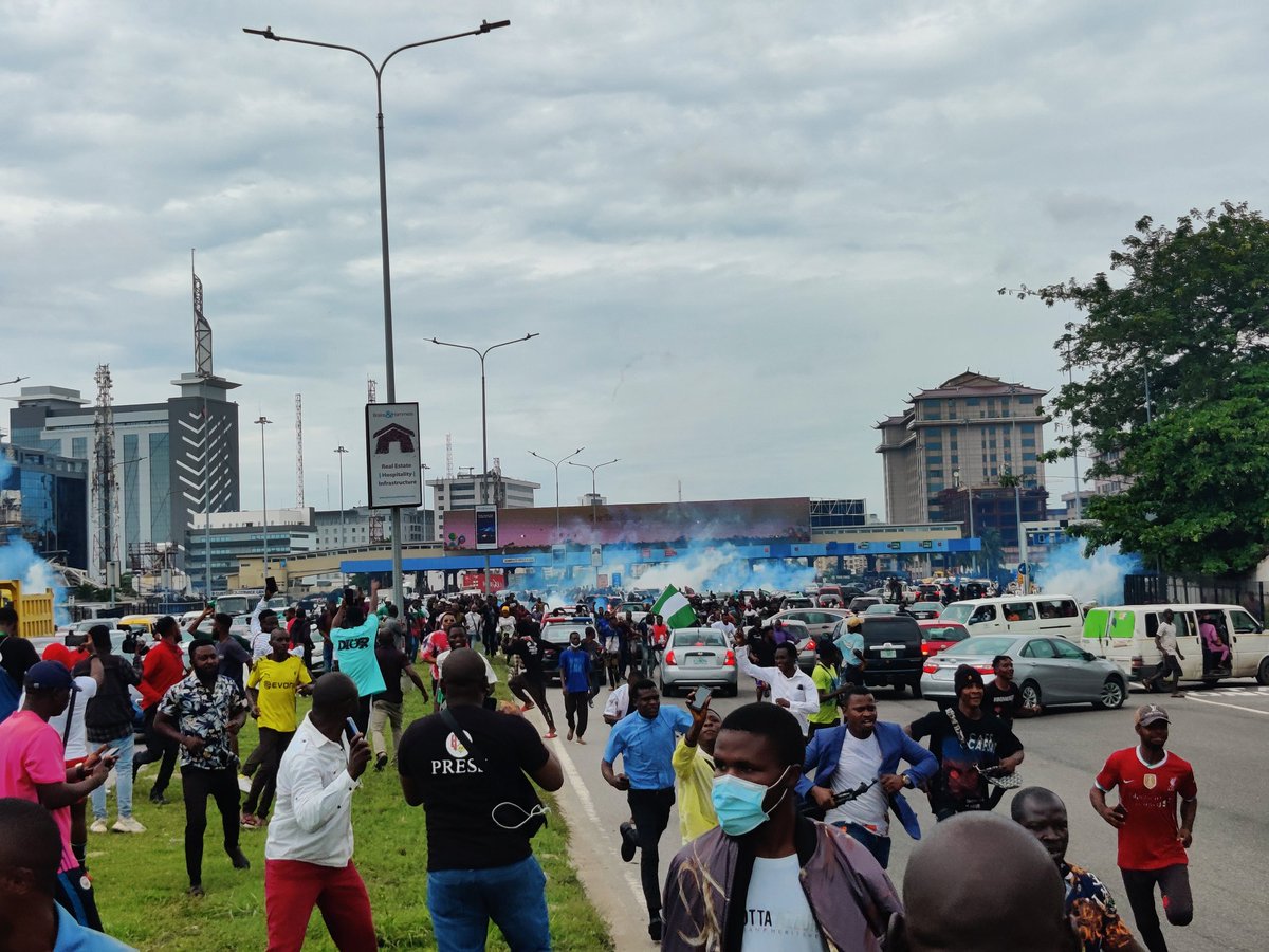 PulseNigeria247's tweet photo. BREAKING: Police officers have started firing tear gas at #EndSARSMemorial protesters at Lekki Toll Gate, Lagos. https://t.co/xF2P2NnkXR