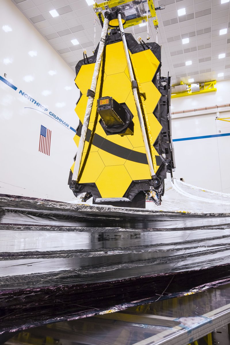 The James Webb Space Telescope with its fully deployed sunshield (resembling a tennis court-sized silver kite with five distinct layers) at the Northrop Grumman cleanroom during testing in Oct. 2019.