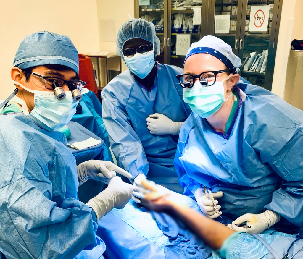 🔪 Scenes from the OR: Resident Ruth Tevlin (PGY4) guiding Resident Luis Camacho (PGY2) through a digital nerve repair with visiting medical student Fortunay Diatta assisting.