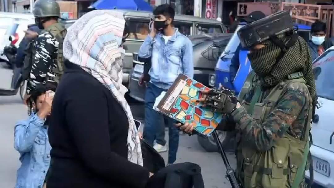 Gaamuk's tweet photo. What possibly could be hidden in a notebook? That this lady CRPF official is holding the book upside down while pretending to read it makes her look ludicrous https://t.co/aOn5urtbZq