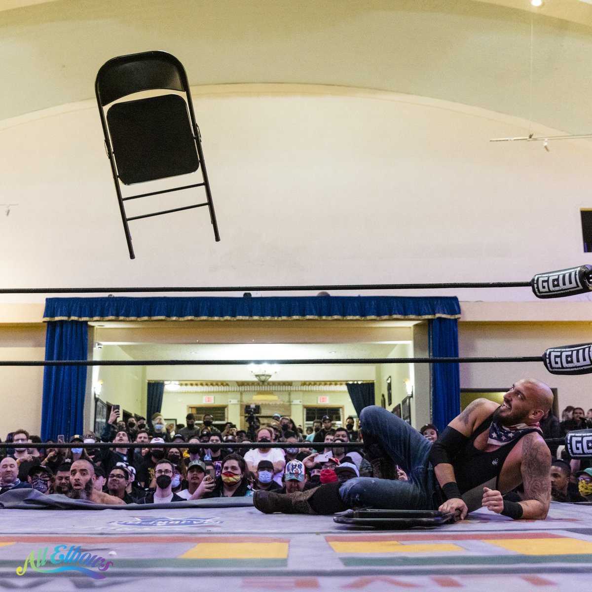 A steel folding chair mid-air, flying to the Game Changer Wrestling ring at wrestler Mance Warner during a tag team title match against the Briscoes.