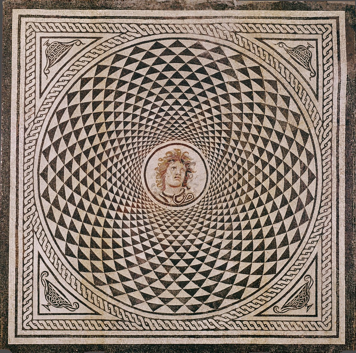 A #Roman mosaic panel, with the head of Medusa in the middle, surrounded by an almost dizzying array of black &amp; white triangles arranged in concentric circles around her - a stunning piece to have in your home! From #Rome, dated c. AD 115-150 #MosaicMonday