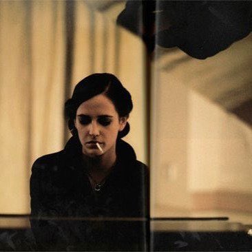 Eva Green taking a break at a piano on the set of 'Casino Royale', photographed by Greg Williams.