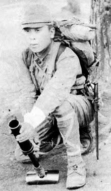 八九式重擲弾筒の正しい撃ち方はこう。英語名は「knee motor(ニー・モーター)」で「膝撃ち迫撃砲」の意味。そのままの意味で画像二枚目のような撃ち方で試し撃ちした米兵の大腿骨をめでたく粉砕した。 