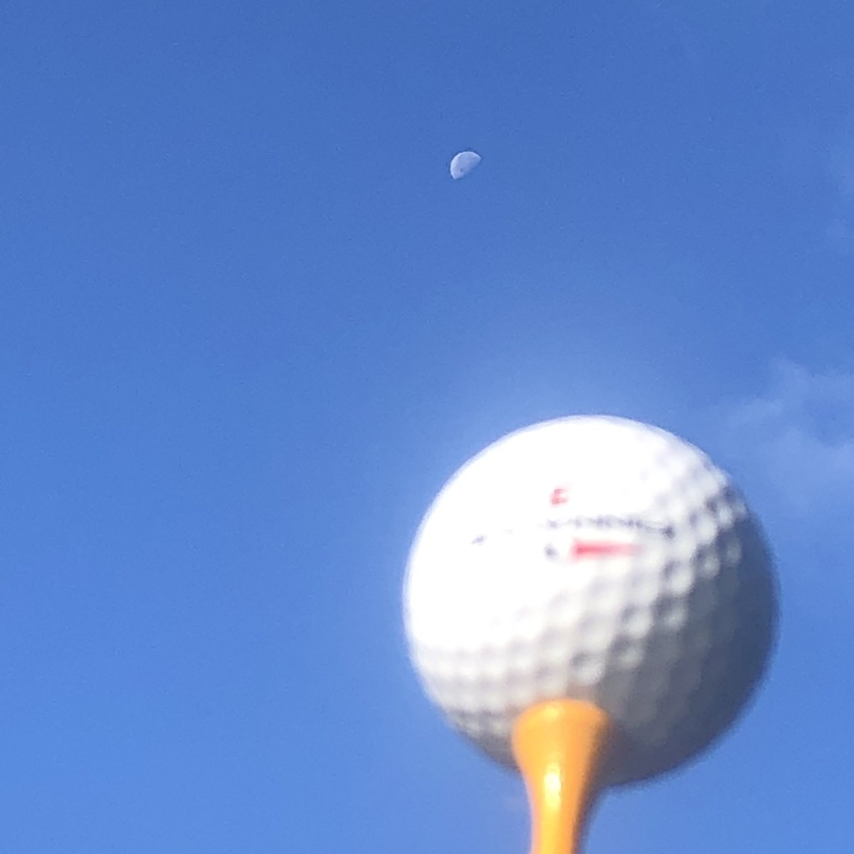 A golf ball and the moon in the same (gibbous) phase.