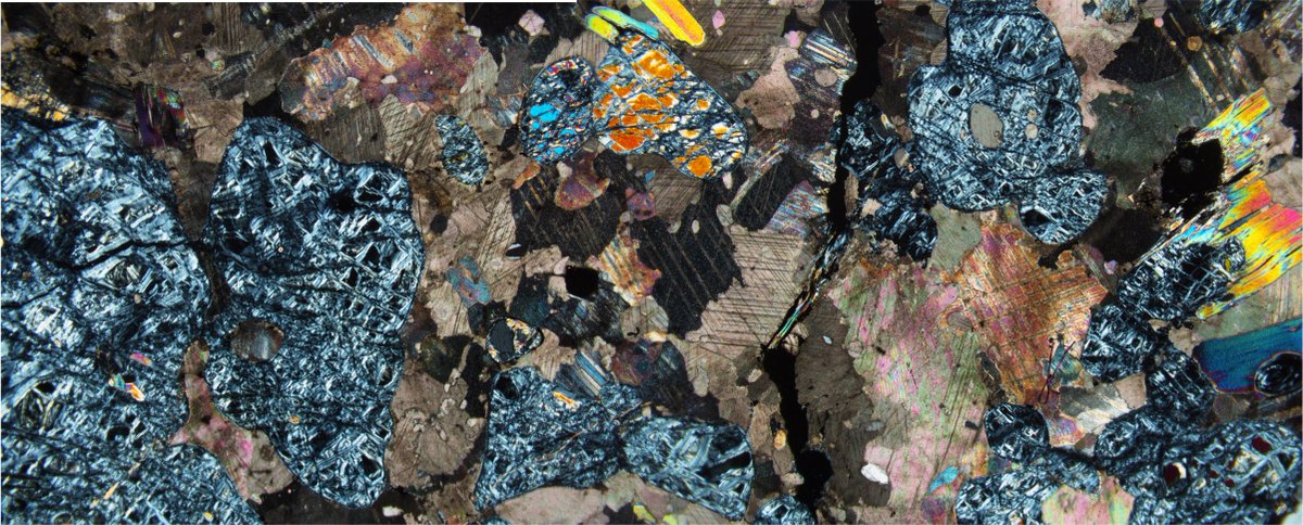 Agpaitic_Adam's tweet photo. Chilly little islands of serpentine and relict olivine floating in a warm sea of calcite. #thinsectionthursday #geology #minerals FOV ~2.5 x 6 mm https://t.co/ckcTXpp17X