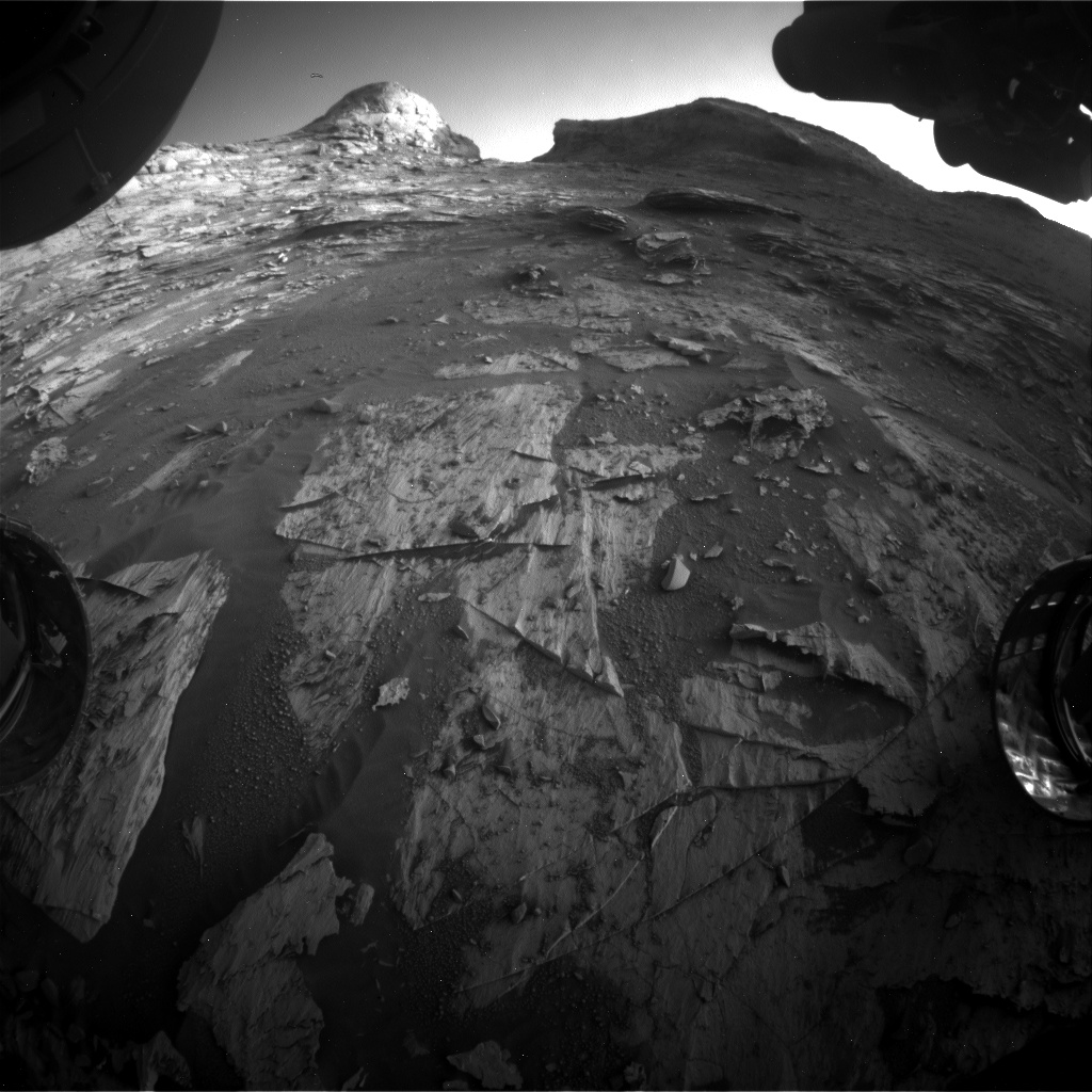 view from under the rover showing wheels and the rocky desert landscape beyond