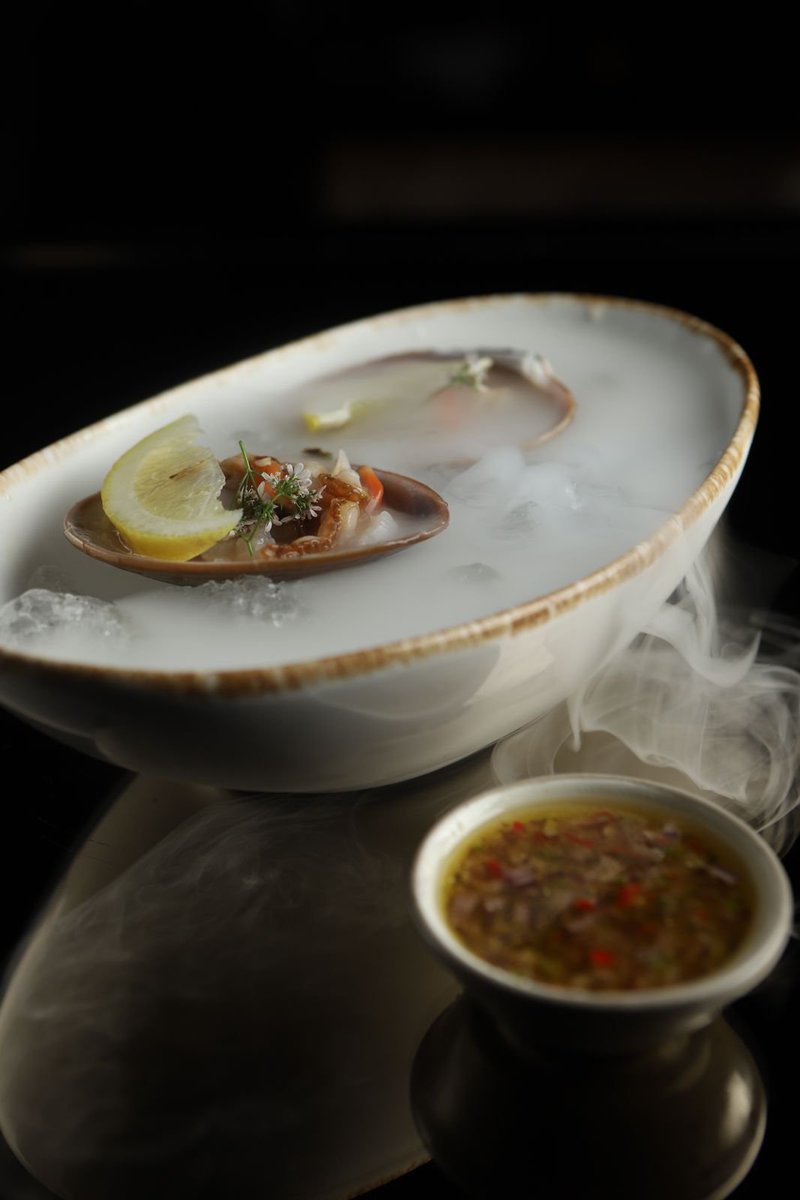FoodandTravelMX's tweet photo. De Baja California, esta almeja chocolata servida con un rasurado de chiles encurtidos con aceite de oliva y jugo de limón resultó en un bocado muy fresco, que se acompañó con el típico cantarito de Jalisco, ahora hecho con el gin @MONKEY_47 #StreetFood2021 #Cachava @mkdavila https://t.co/qBDnLET4iN