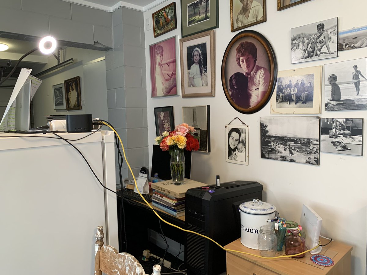 SachaCoburn's tweet photo. Turns out the modem is in the basement garage so I set up downstairs. Laptop on an old fridge, notes behind the laptop, ring light, microphone resting on the fridge, roses on some old books, vintage photos for the backdrop. Good times! #number8wire #keynotespeaker #noexcuses https://t.co/tdfXYJghNf