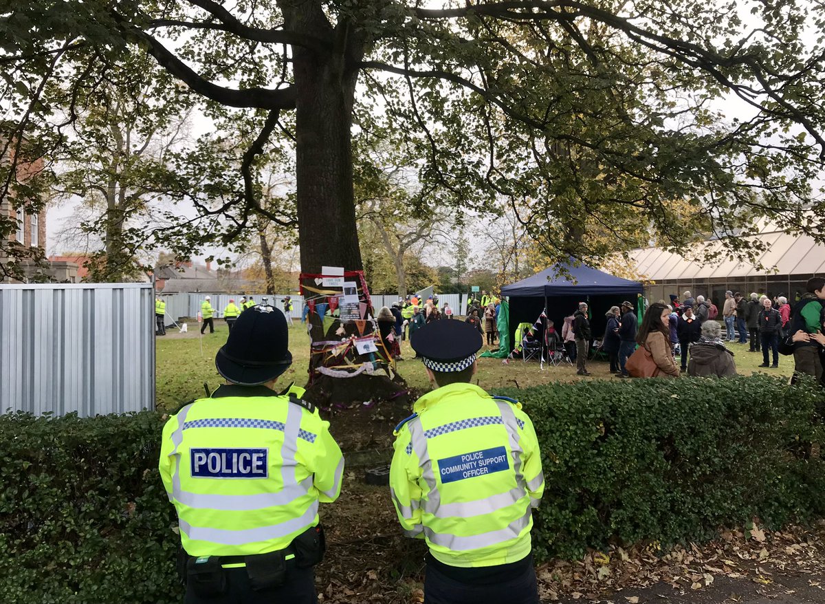 AdamCormack_'s tweet photo. Police watching fences go up at Newark Library Garden while local residents gather to try to defend the garden and its mature trees. The trees are due to be felled for an unnecessary car park extension 💔 /1 https://t.co/UkxX7GDQQV