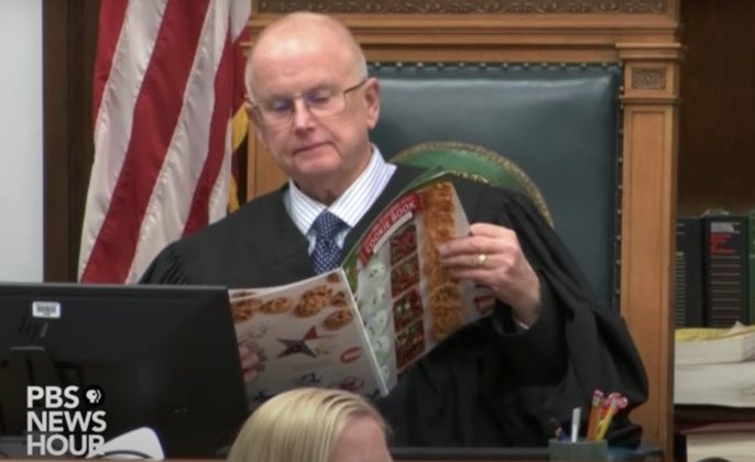 GenZPerspectiv's tweet photo. Here is Judge Bruce Schroeder reading a cook-book during testimonies. Then, the Judge’s phone range in the middle of the Prosecution’s line of questioning. Also, his ringtone was Trump's rally theme song, "God Bless the USA." This is what bias looks like. #KyleRittenhouseIsGuilty https://t.co/IlcJplslyM