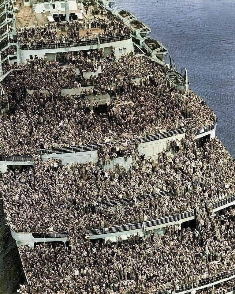 The RMS Queen Elizabeth pulling into New York with service men returning home after the end of World War 2, 1945.⁣What a photo!