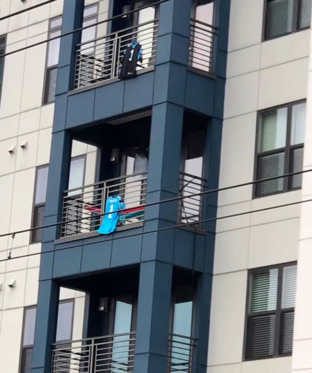 KeepBlitzin's tweet photo. Panthers fans are hanging Cam Newton jerseys on the outside of their balconies in Uptown Charlotte. https://t.co/bUxA3W4eQ0