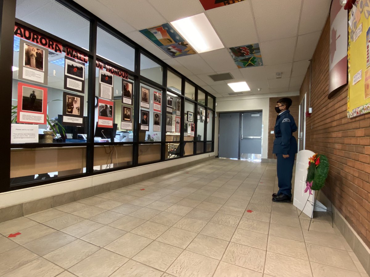 pdangsta's tweet photo. Aurora Charter School cadet at attention beside the wreath and facing the Wall of Honour - family members of Aurora students and staff who served in the armed forces.  Lest We Forget. @aacsSchCouncil @AACSMiddle https://t.co/OgSlBtXPpD
