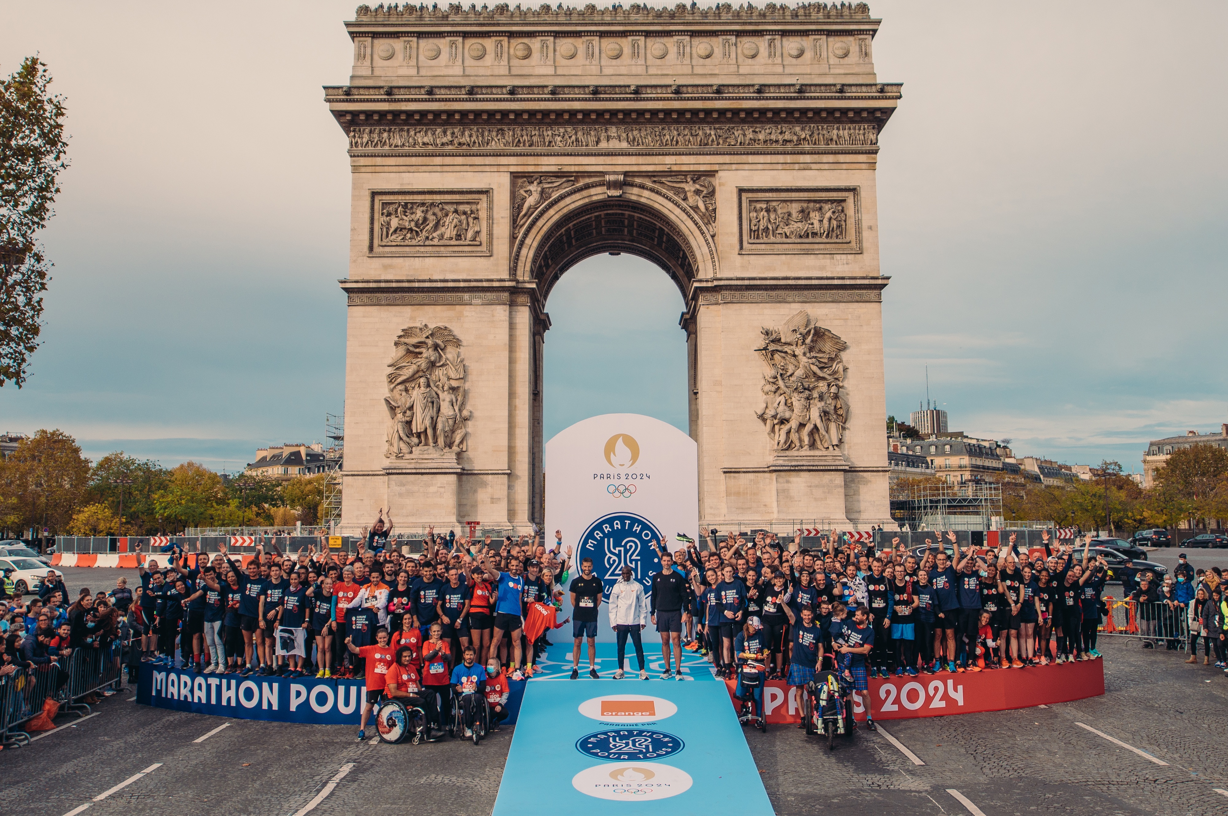 Les vainqueurs du marathon pour tous Paris 2024 devant l'arc de triomphe.