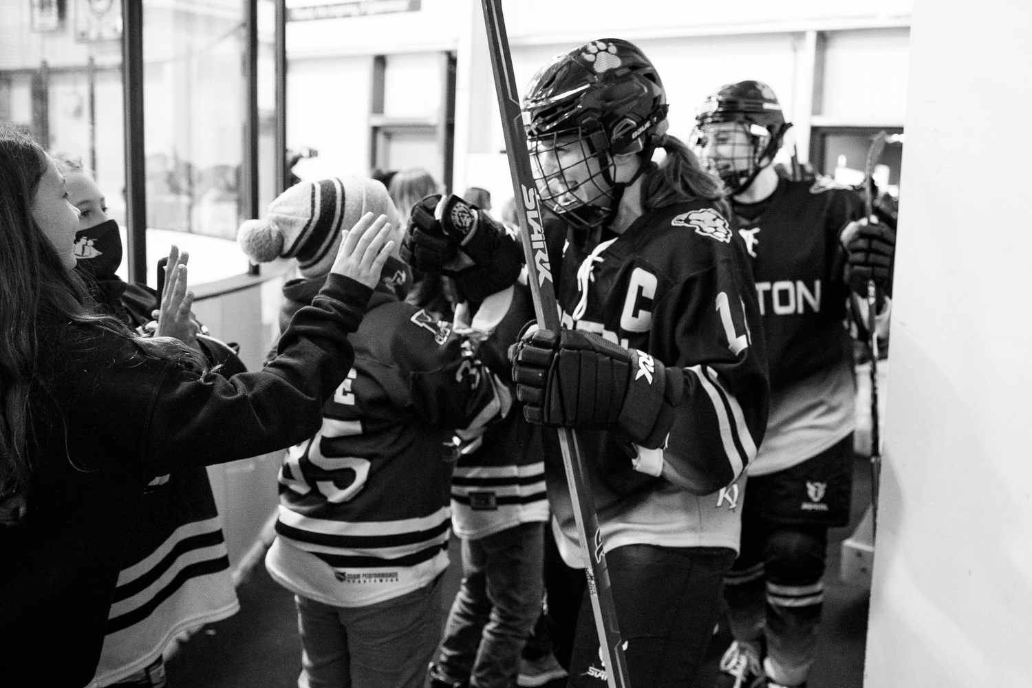 Boston Pride greeted outside the locker room with fist bumps from Falmouth youth girl's hockey players
