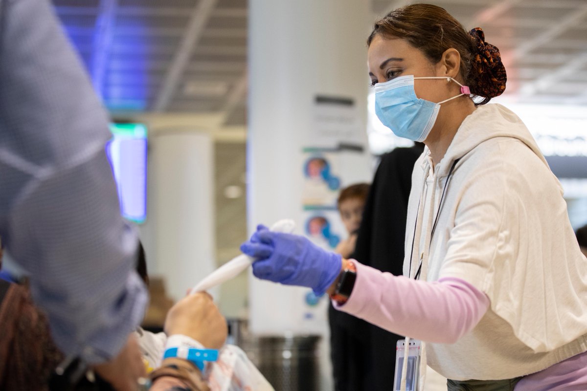 Reyna Pinel-Ponce, a Department of State employee, hands out snack bags and other necessities to Afghan guests as they arrive in the Philadelphia International Airport, October 22, 2021.