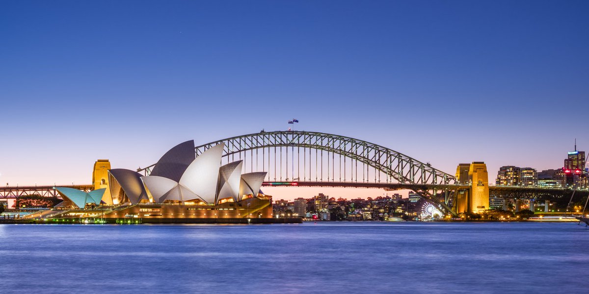 The Sydney Opera House and Sydney Harbour Bridge, two of Sydney's most famous landmarks, photographed at dusk