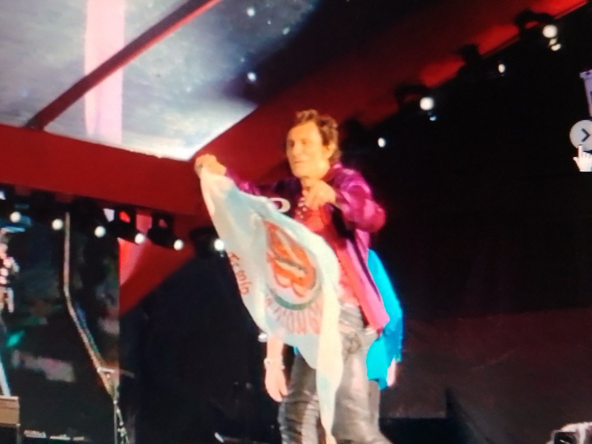 tonysoulman's tweet photo. Momento exacto en que @ronniewood levanta la bandera argentina que le dio Franco de @essolorolling en el show de Tampa y la respuesta de @SallyWood diciendo que tienen la bandera en la habitación. https://t.co/C4G9ubhlS9