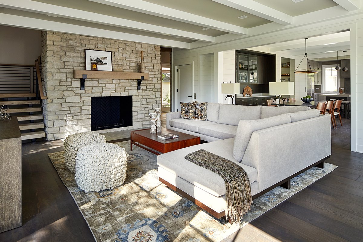 Attention-to-detail abounds in this contemporary Wisconsin getaway designed around a 3-story stone wall. Tribal styled hand knotted rugs mix beautifully with the wood, metal and leather elements in the home. View more photos in our portfolio: bit.ly/2Zc4nAS