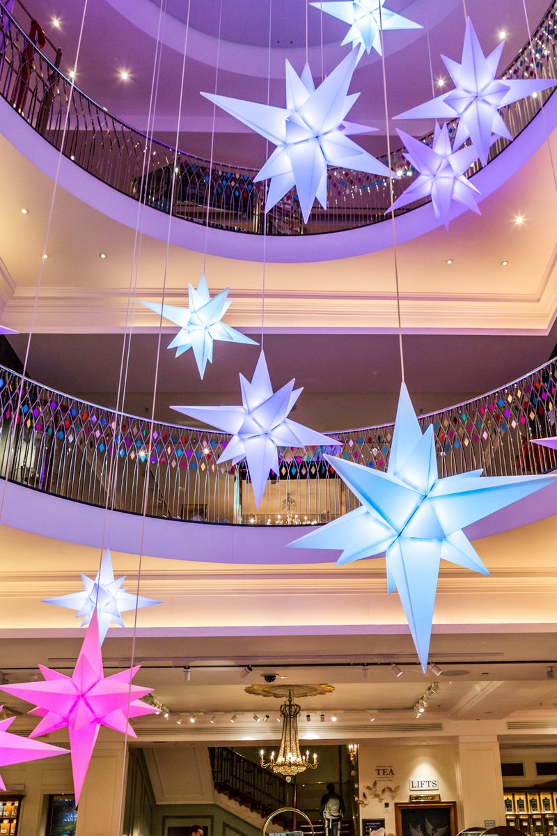 Fortnums's tweet photo. Stargazing in Piccadilly! ✨ Levitating in the atrium of our Piccadilly home this #FortnumsChristmas, a galaxy of kaleidoscopic stars float above as they slowly change colour throughout the day. With a different outlook from every floor, no two starry-skies are quite the same. https://t.co/hSSGil9Wyu