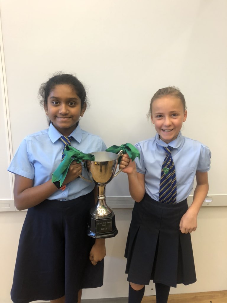 OLM_Primary's tweet photo. Our proud St Mirin captain & vice captain show off the house cup. 3 months in a row with the green ribbons of St Mirin on our house cup 🏆 #celebratingachievement #visionvaluesaims #pupilleadership @DoPEducation1 https://t.co/PAA9yIc7WI