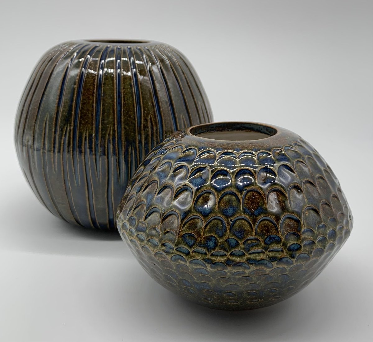 CeramicsClai's tweet photo. Stoneware scalloped bud vase and carved vessel . I love how the blue in this glaze pools in the recessed parts of these pots .  #pottery #potterylove #ceramics #clay #ceramicsofinstagram #stoneware #handmade #handmadeceramics #pottersofinstagram #ceramicart #glaze https://t.co/Je6JP5Mio6