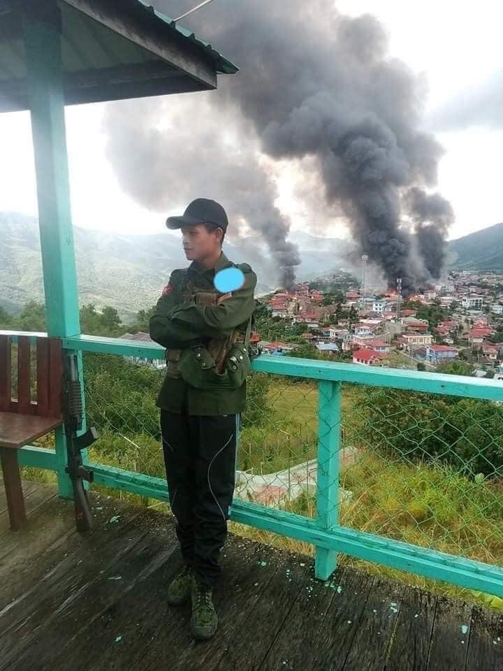 Picture circulating on social media shows Myanmar military soldier posing with Thantlang town burning in the background. Over 160 households and two prominent churches were destroyed in the incident on Friday per <a href="/mizzima/">eL ima</a> news. 

#WhatsHappeningInMyanmar