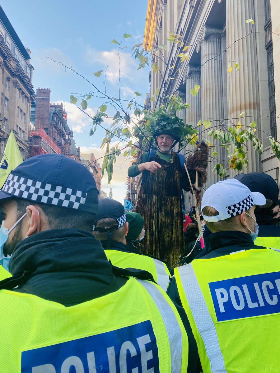 jamesmatthewsky's tweet photo. Police block demonstrator dressed as a tree. Someone shouts “Are you Special Branch?” #patter #COP26 https://t.co/dS2LcL8miH