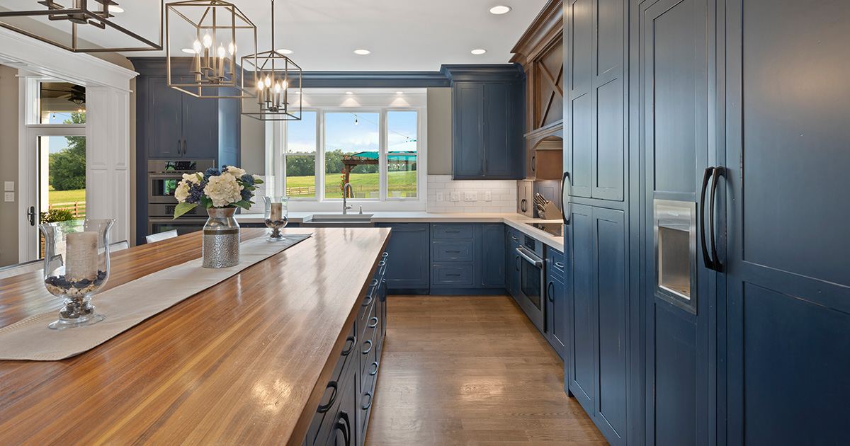 The kitchen, widely considered the heart of the home, deserves a space as large and expensive as the feeling of warmth it gives to us. From farmhouse to modern, a butcher block countertop and a dark slate blue paint help anchor the kitchen.

Photo Credit: Greg Grupenhof