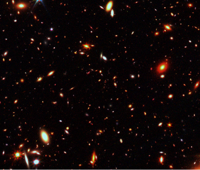 Simulated data of deep survey images that will be used to help the Webb Telescope NIRCam instrument team search for the first galaxies. Shows several orange specks and glowing dots on a black background.