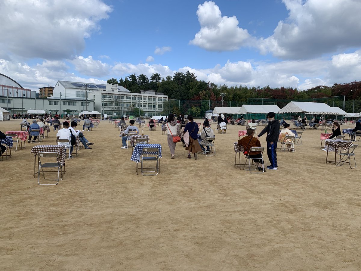 グラウンドでは屋外企画と模擬店企画が出展されています。食事スペースは全員が同じ方向を向いて飲食できるよう設置されています。