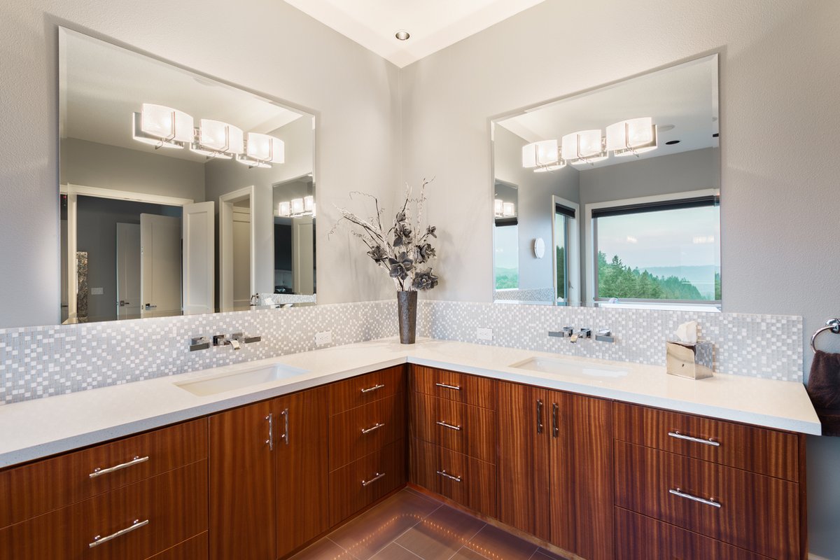 Good morning! White and wood continues to dazzle. This unique stained floating vanity functionally uses a corner with two sinks with a beautiful uniform white quartz surface. What do you think?